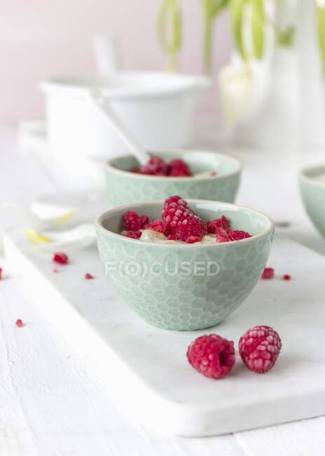 Blue mini bowls of porridge with raspberries — Stock Photo