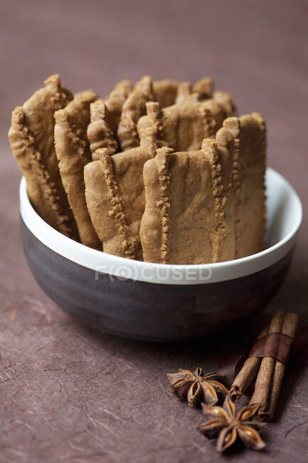 Gingerbread biscuits in small bowl with cinnamon and anise — Stock Photo