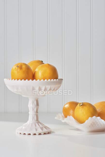Oranges mûres fraîches dans un bol en verre sur fond blanc — Photo de stock