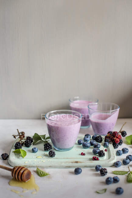 Yoghurt in cups made with blackberries and blueberries with honey — Stock Photo