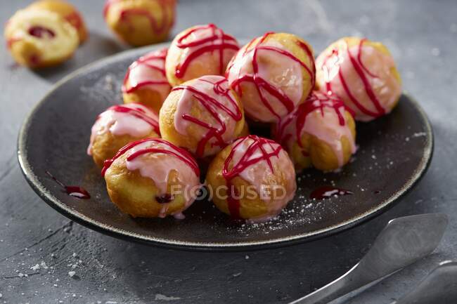 Jam filled doughnuts with a pink sugar glaze — Stock Photo