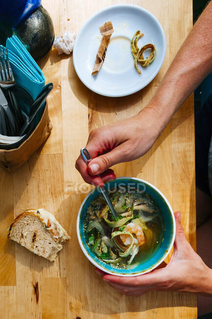 Una taza de sopa de fideos en una mesa en un restaurante - foto de stock