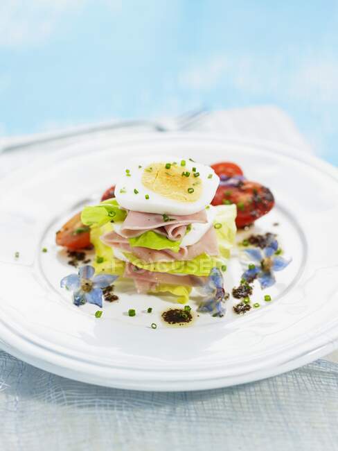 Stack of lettuce, ham and egg with chives — Stock Photo