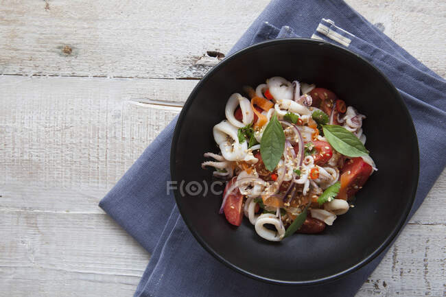 Baby squid salad with tomatoes, onions and dressing — Stock Photo