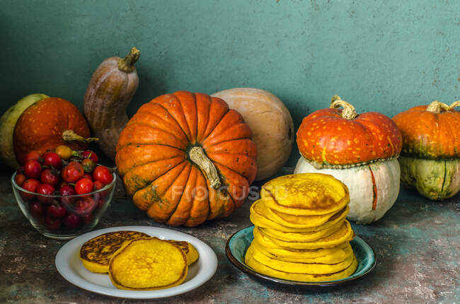 Autumn still life with pumpkins and pumpkin pancakes — Stock Photo