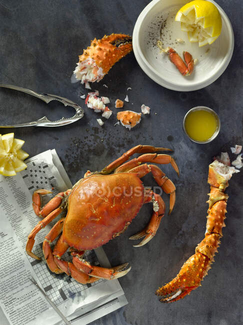 Cooked crab with a pair of crab crackers, melted butter and lemon — Stock Photo