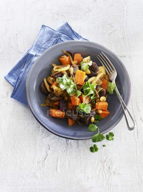 A tagine with root vegetables, apricots and almonds — Stock Photo