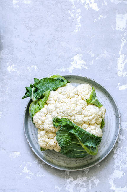A fresh cauliflower on a ceramic dish — Stock Photo