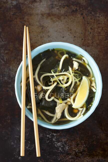 Asian-style chicken broth with wakame and lemon — Stock Photo