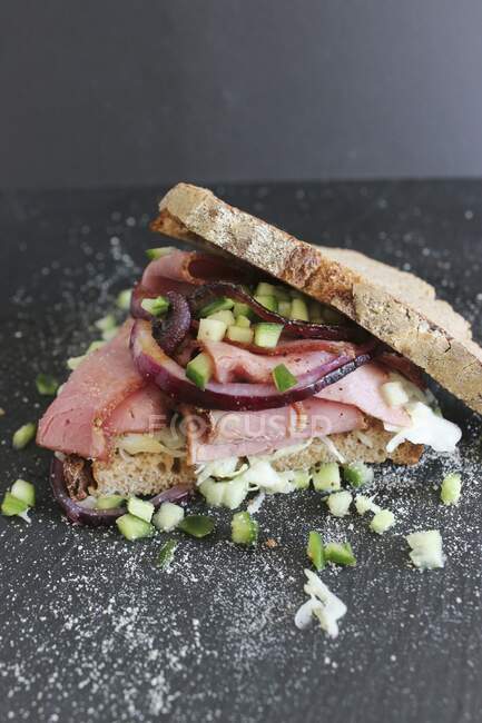 A pastrami sandwich with pieces of cucumber — Stock Photo