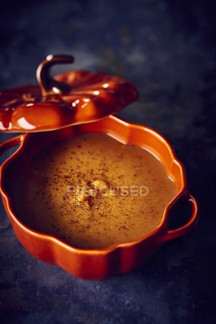 Butternut squash soup with chestnuts in an orange tureen — Stock Photo