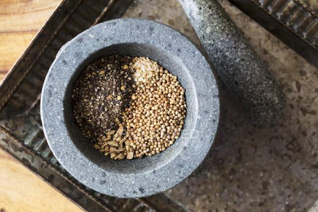 Pimenta, gengibre, sementes de coentro e alho em uma argamassa — Fotografia de Stock