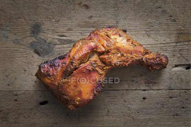 Perna de frango tandori em um fundo de madeira — Fotografia de Stock