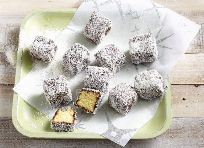 Sponge cake bites with chocolate glaze and grated coconut — Foto stock