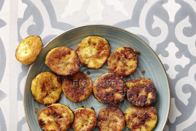 Жареный картофель с сыром и чесноком на тарелке — стоковое фото