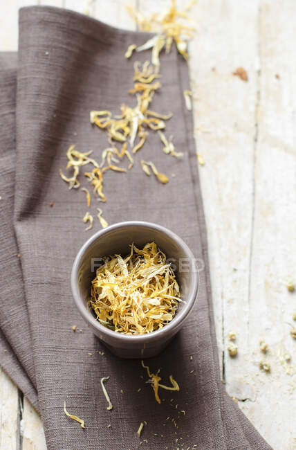 Edible yellow flowers in a bowl and a linen cloth — Stock Photo