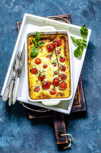 Clafouti pie with cherry tomatoes on branch — Stock Photo