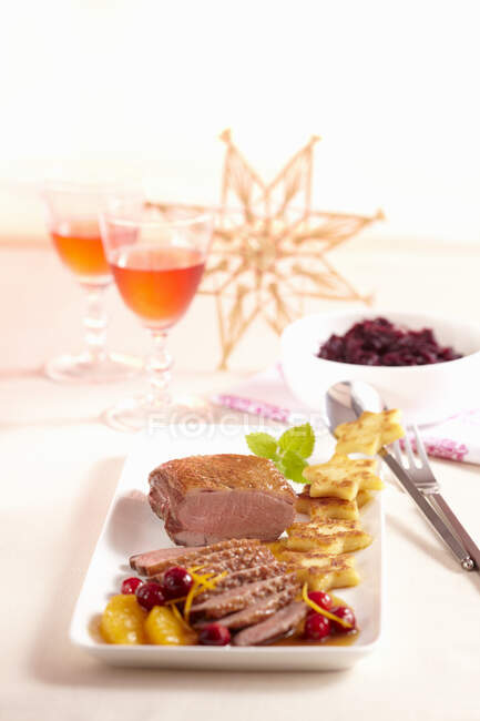 Rare duck breast with a fruity orange and cranberry sauce, fried potato stats and red cabbage — Stock Photo
