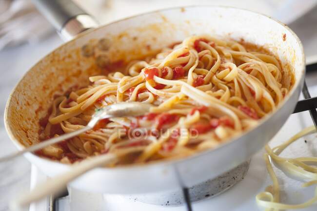 Linguine with tomato sauce in a pan — Stock Photo