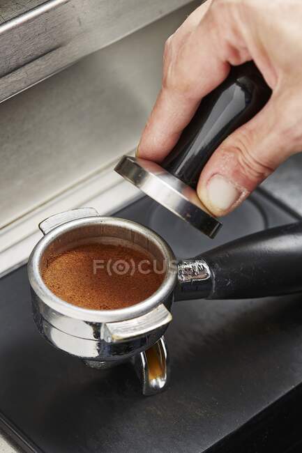 A coffee press with a tamper - foto de stock