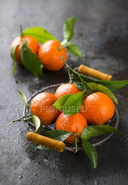 Mandarinen mit Blättern im Korb — Stockfoto