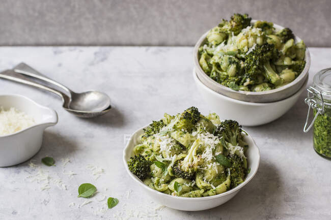 Conchiglie di pasta con pesto di basilico e broccoli arrosto e parmigiano grattugiato — Foto stock