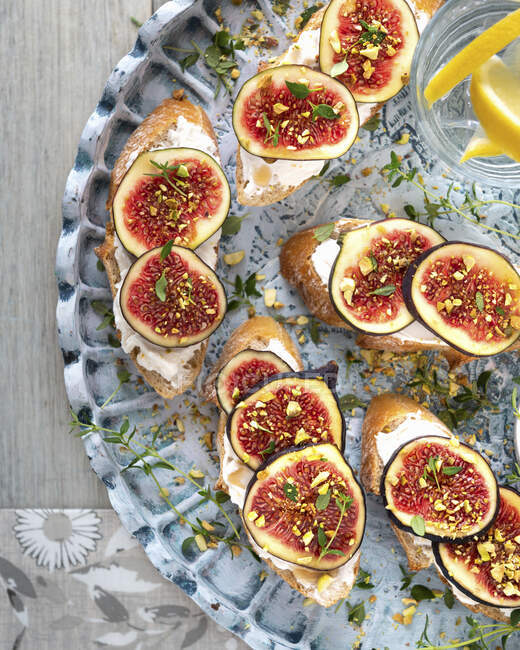 Figs on bread toasts with ricotta cheese and herbs — Stock Photo
