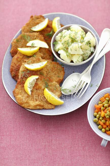 Pork schnitzels with potatoes, carrots and peas — Stock Photo