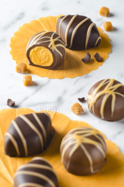 Chocolate pralines filled with caramel on a marble background — Stock Photo