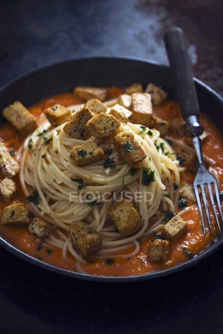 Spaghetti with tomato and carrot sauce and fried tofu (vegan) — Stock Photo