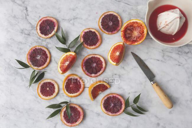 Кровь апельсина ломтики с цитрусовым прессом — стоковое фото