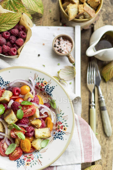 Tomato salad with raspberries, onions and croutons — Stock Photo