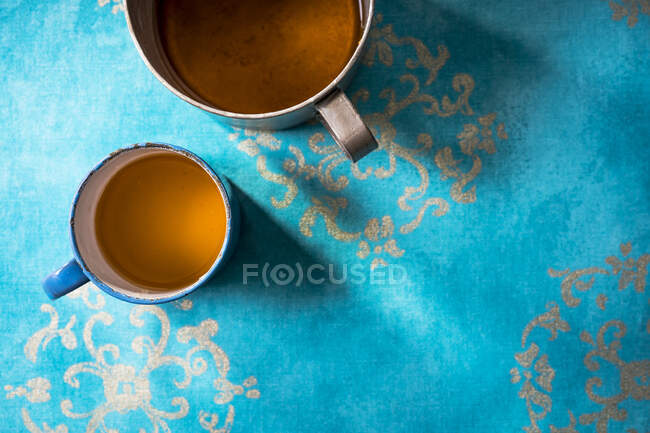 Coriander and ginger tea in a metal cup on an azure blue surface — Stock Photo