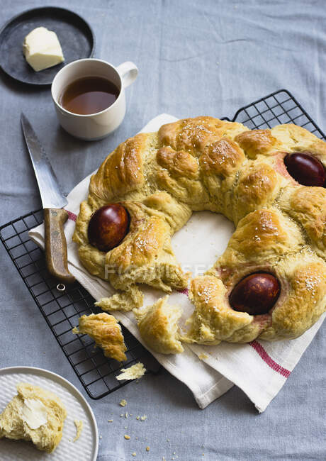 Greek Easter bread with boiled eggs, served with tea and butter — Stock Photo