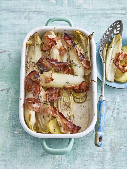 Tin of chicory bake with bacon and date syrup — Stock Photo