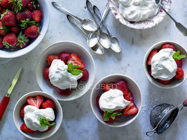 Erdbeeren mit Schlagsahne in Schalen, von oben — Stockfoto