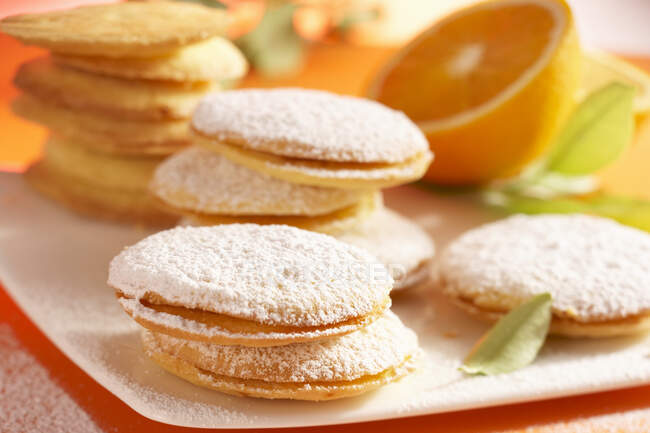 Orange cookies filled with jam and dusted with powdered sugar — Stock Photo