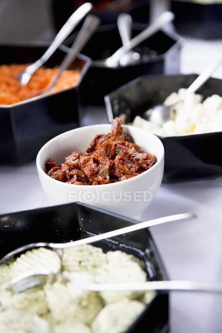 Dried tomatoes and marinated vegetables on a buffet — Stock Photo