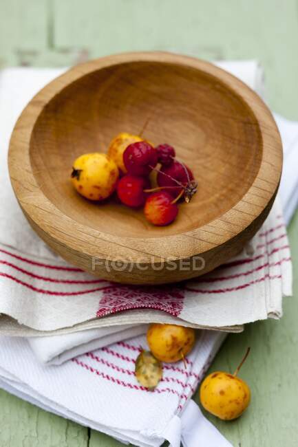 Decorated apples in a wooden bowl on kitchen towel — Stock Photo