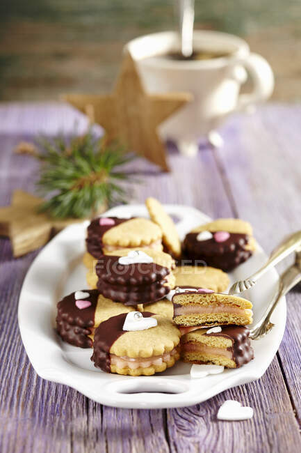 Cookies filled with marzipan and pineapple jam with chocolate glaze on plate — Stock Photo