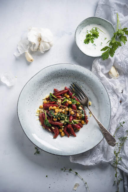 Beetroot orzo pasta with chickpeas, spinach and herb sauce — Stock Photo