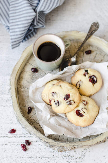 Cookies with berries and coffee cup on wooden tray — Stock Photo