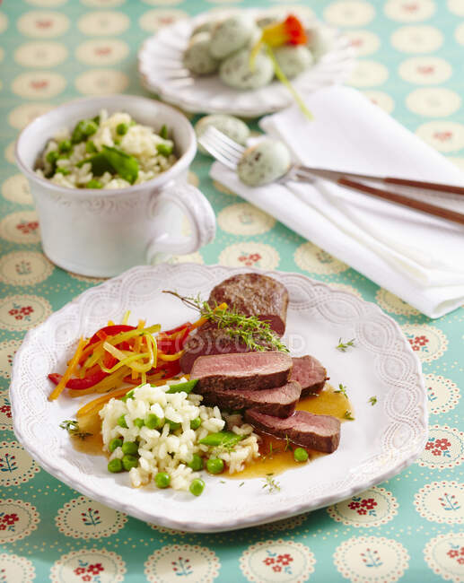 Roast saddle of lamb with a pea risotto and julienned vegetables for Easter — Stock Photo