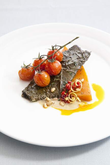 Filetto di pesce tamburo rosso con pomodorini fritti e pinoli — Foto stock