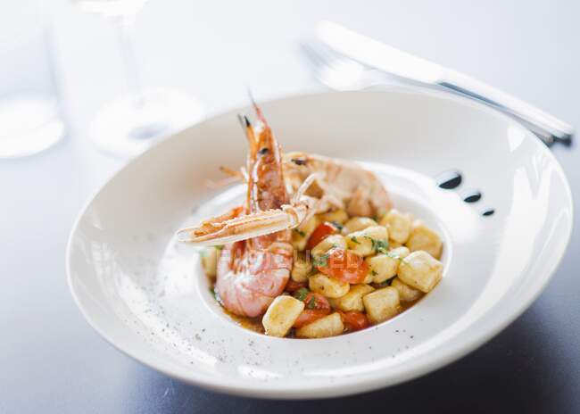 Gnocchi in fish sauce with scampi and prawns — Stock Photo