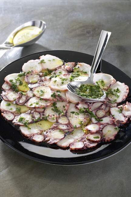 Carpaccio of octopus with herb oil — Stock Photo