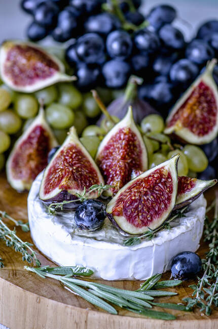 Сыр Камамбер с инжиром, медом, виноградом и душистыми травами — стоковое фото