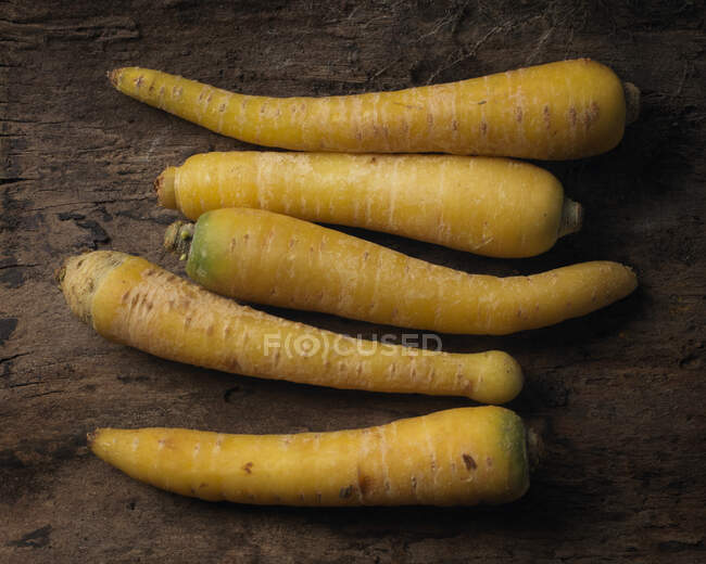 Yellow carrots on rustic wooden surface — Stock Photo