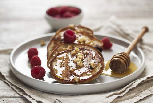 Quark and buckwheat pancakes with blueberries, raspberries and a honey nut topping — Stock Photo