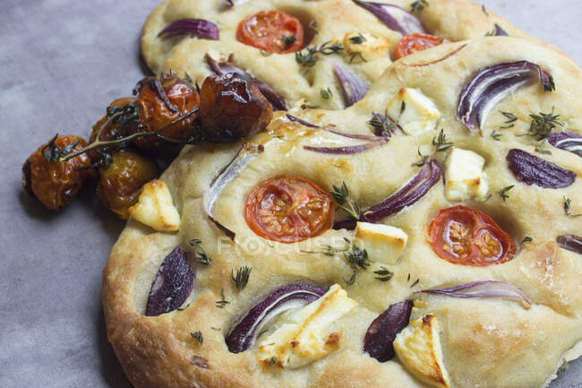 Focaccia with tomatoes, onions, cheese and herbs — Stock Photo